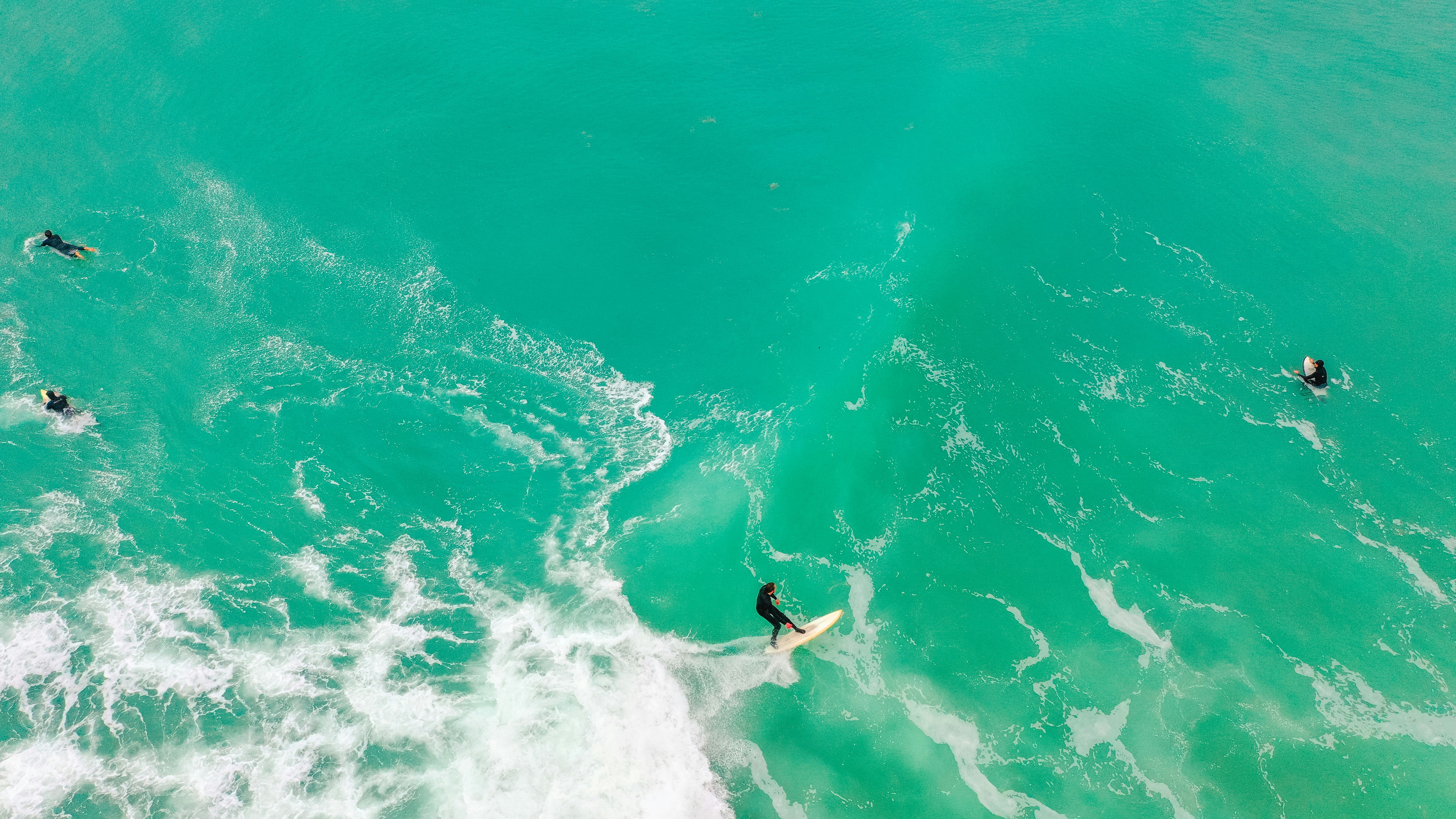 man surfing on sea waves during daytime